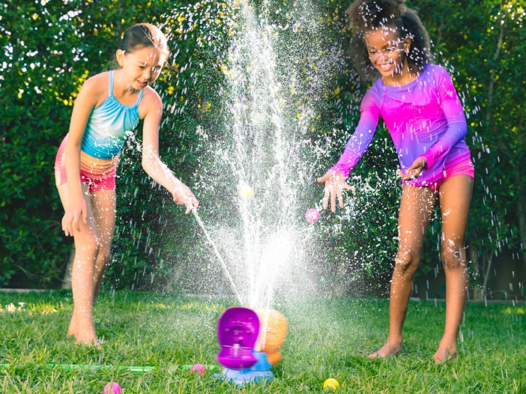 two girls playing with a Hungry Hippos sprinkler game