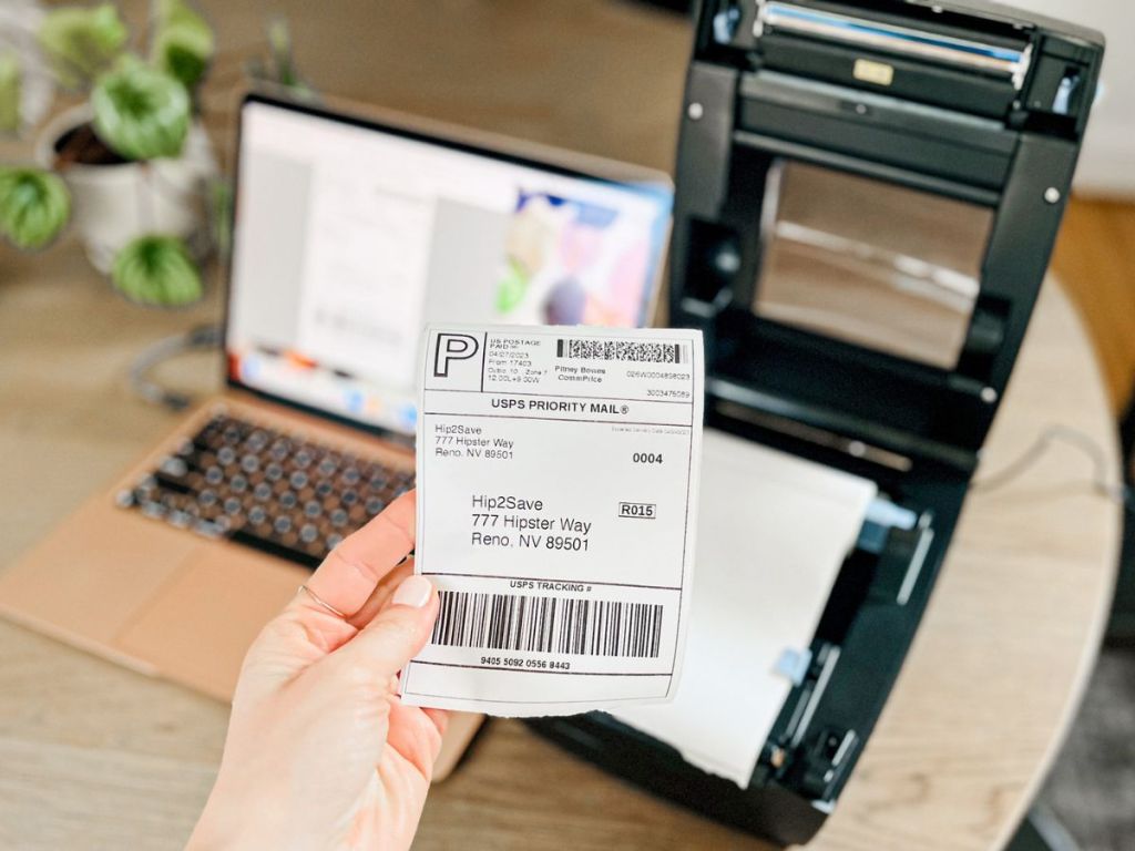 hand holding up a freshly printed shipping label in front of a IDPRT Thermal Printer