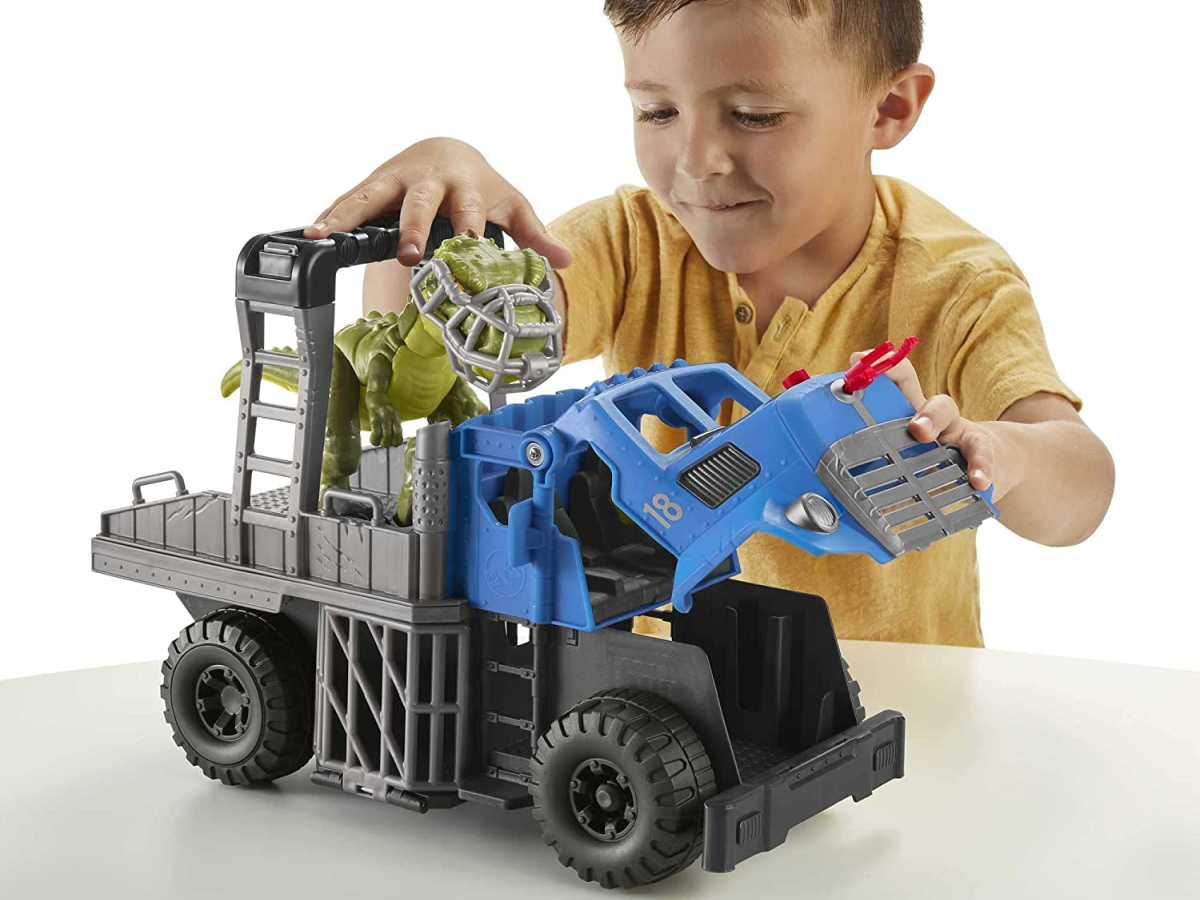 little boy playing with a Imaginext Jurassic World Dominion Break Out Dino Hauler Vehicle