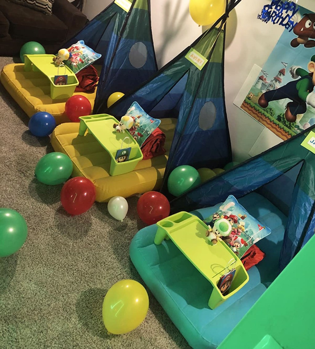kids air beds inside of play sets with balloons on the floor