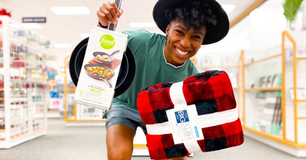 woman holding kohls brand items blanket and food network pans
