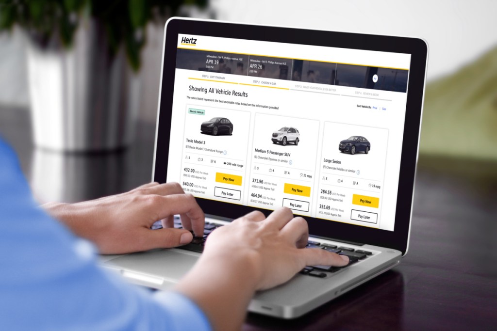 Man browsing the Hertz website to find the cheapest car rental