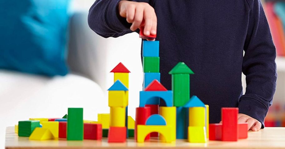 Boy playing with the Melissa & Doug 100-Piece Wooden Building Block Set