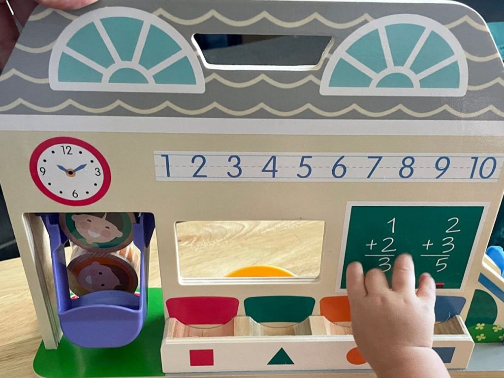 little child hand playing with Melissa & Doug Go Tots Schoolyard