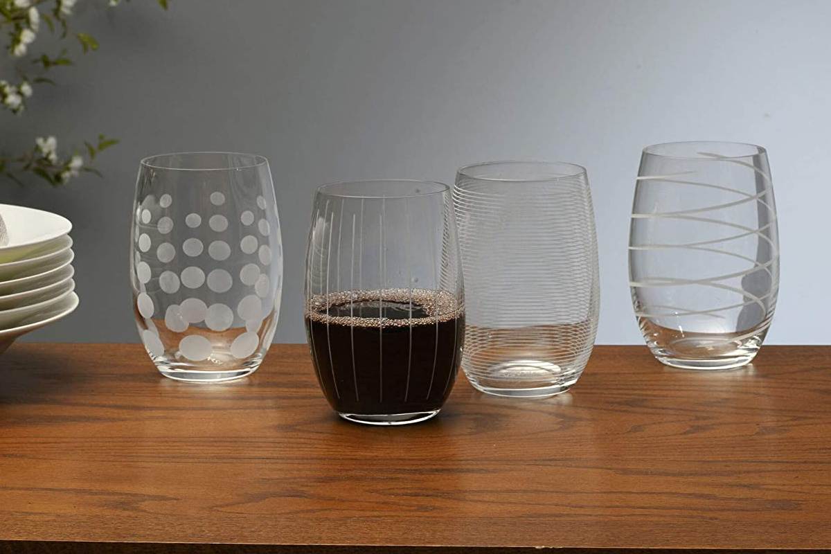 four Mikasa drinkware with one filled with soda
