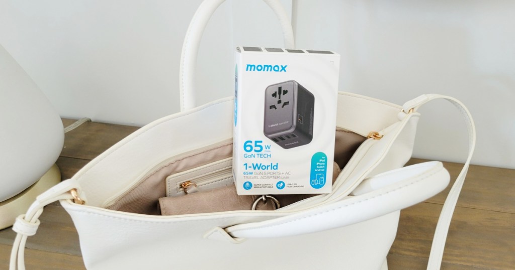 travel adapter sitting on top of white purse