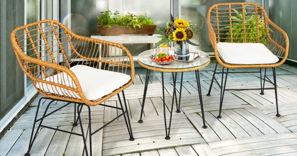 two wicker chairs with cushions and matching table on patio