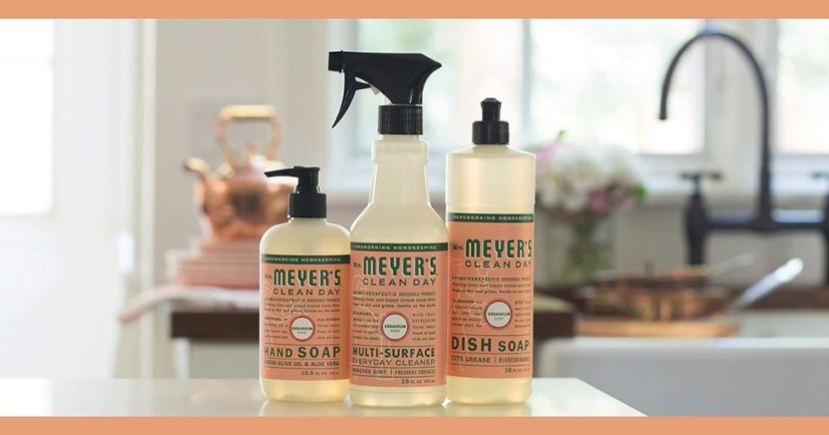 3 mrs meyers products in geranium scent on a kitchen counter - hand soap, dish soap and everyday spray cleaner