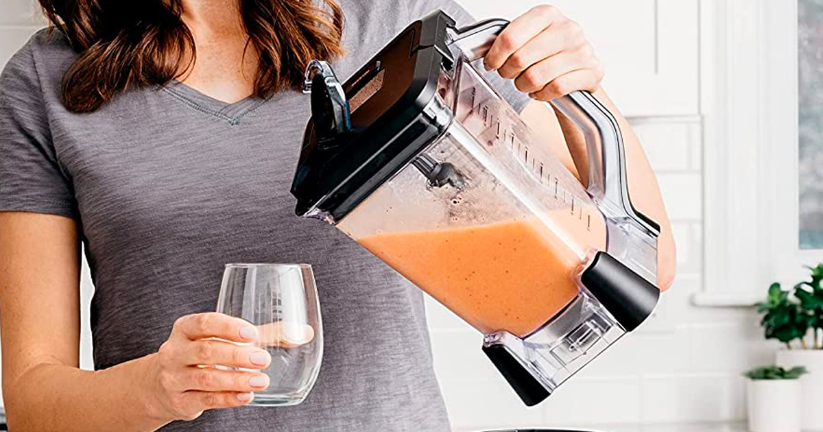 Ninja Professional Blender being used to pour a smoothie by a woman in a kitchen