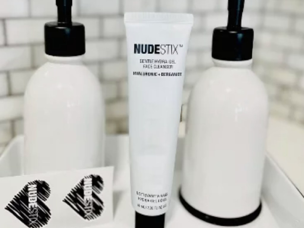 white tube of face wash in between two white bottles