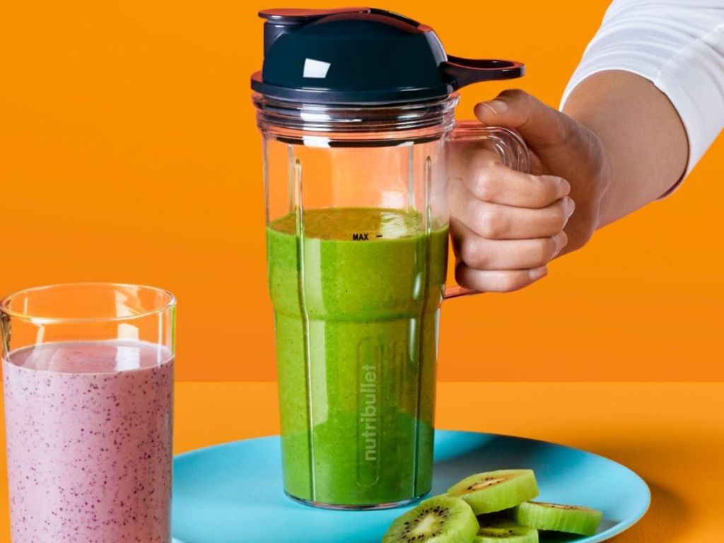 Nutribullet Portable Blending Cup with handle filled with green smoothie