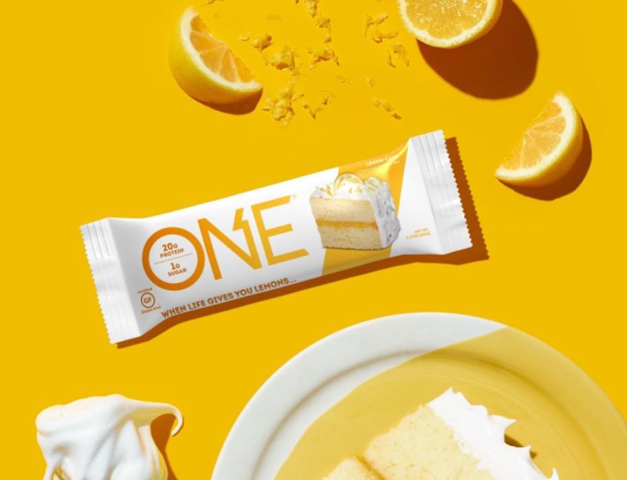 a one protein lemon cake bar shown with lemon wedges and a slice of lemon pie