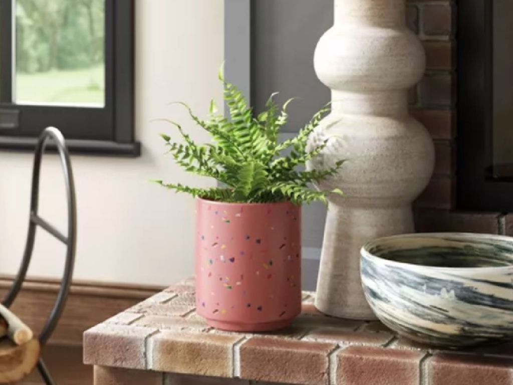pink planter on fireplace ledge