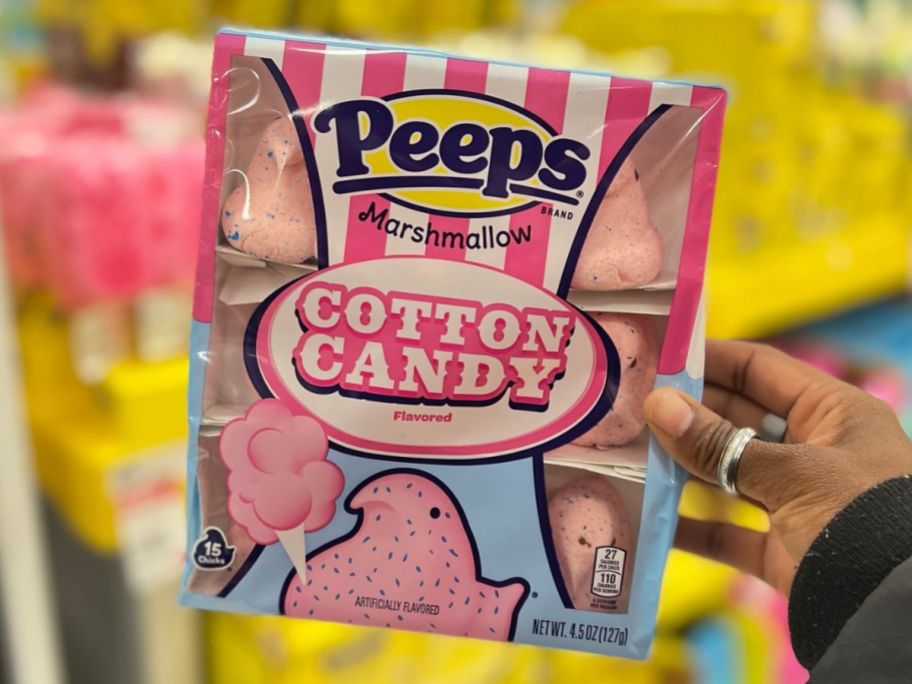 A hand holding a pack of Cotton Candy Peeps