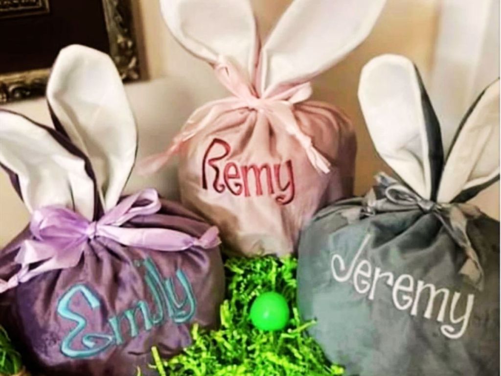 velvet bags with bunny ears tied with ribbon and personalized with names on the front