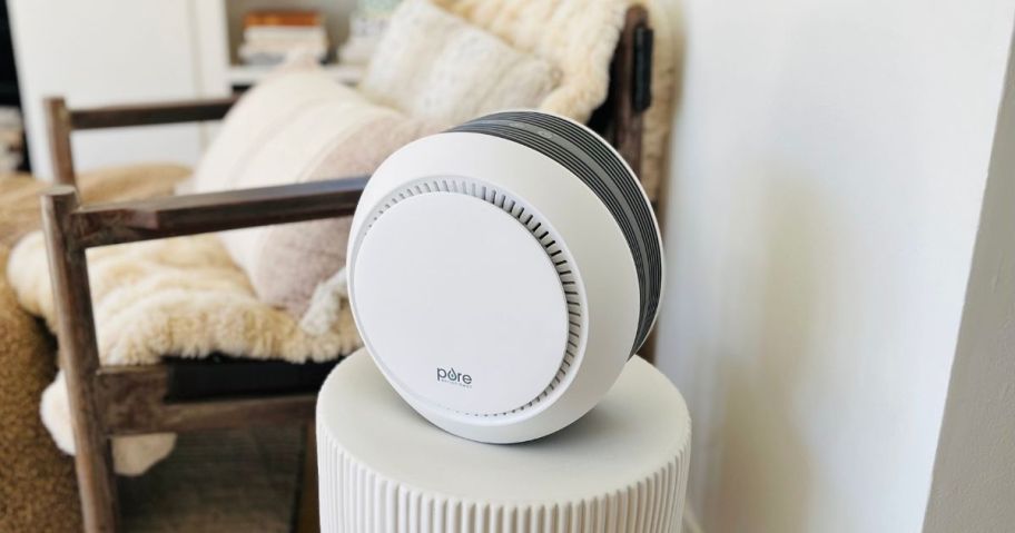 Air purifier on a stand next to a chair