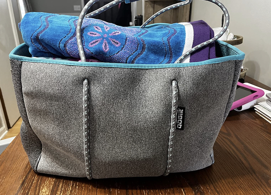 gray tote bag with beach towels inside