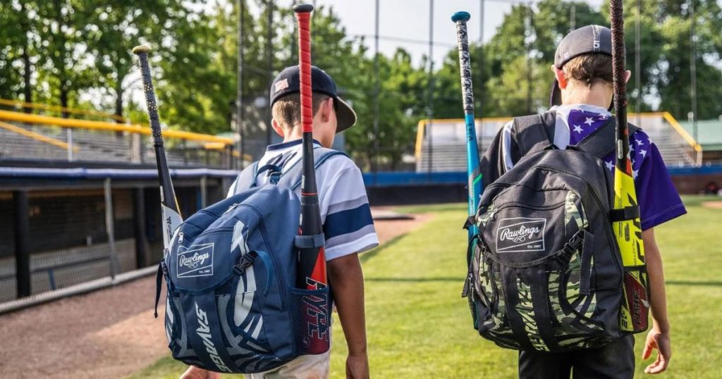 Two boys on a baseball field wearing Rawlings backpacks