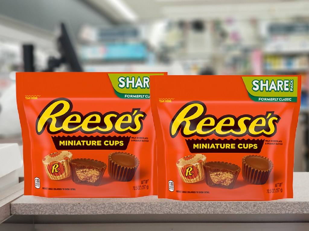 two sharing size bags of reese's miniatures on a ledge