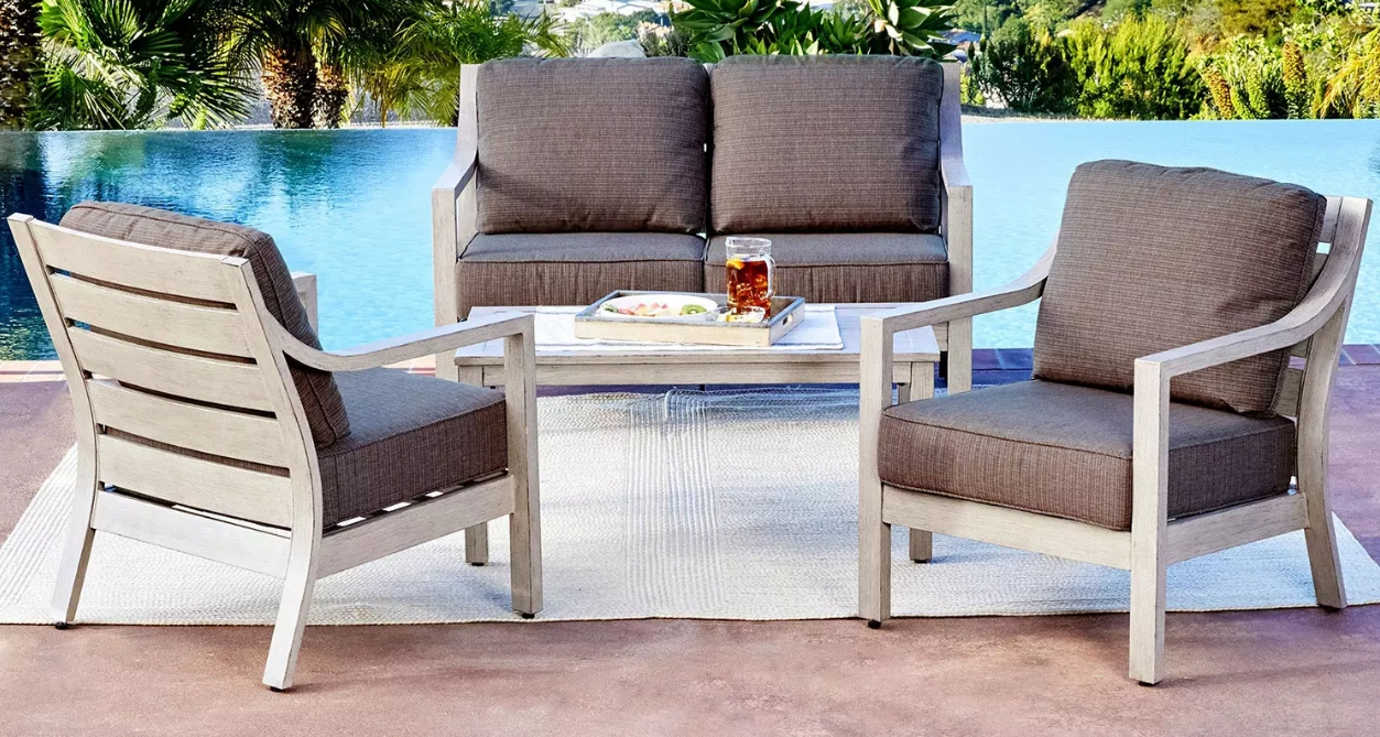 Large patio set next to a pool with two chairs, a coffee table, and a loveseat