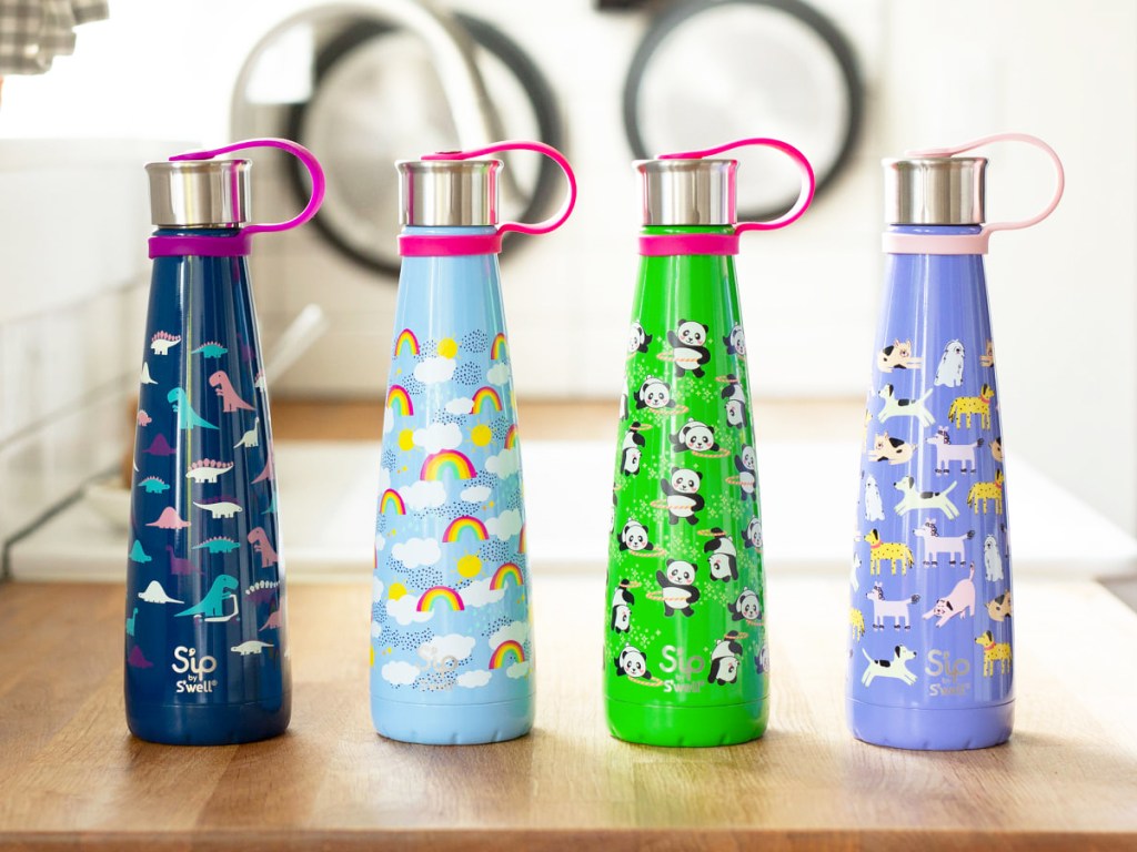 four printed water bottles on a wood table