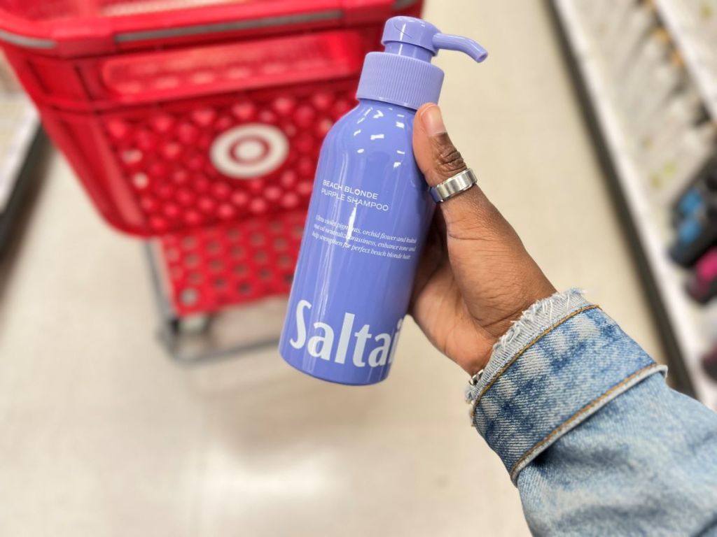 Hand holding a Saltair beach blonde shampoo bottle