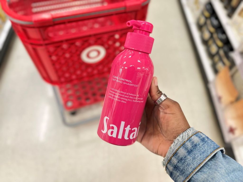 Hand holding a Saltair curl defining shampoo bottle
