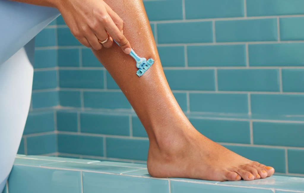 woman shaving her legs