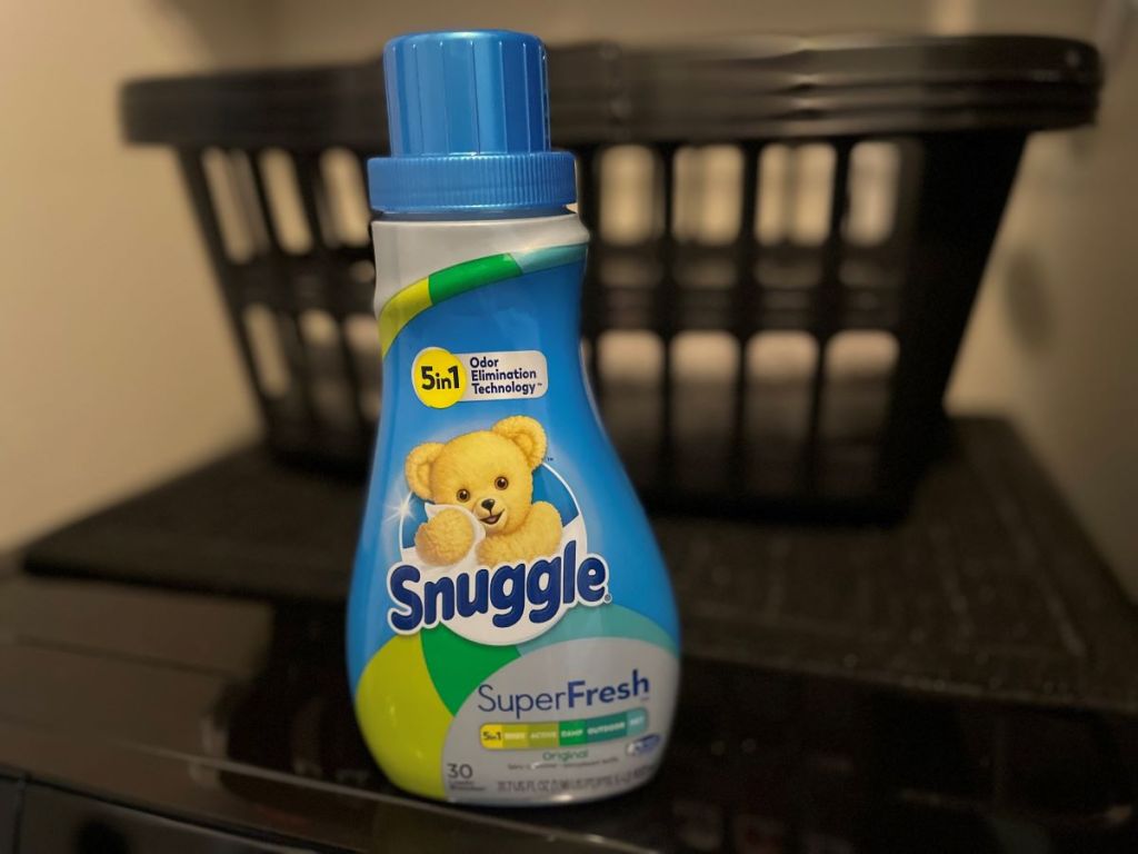 bottle of Snuggle Fabric Softener with laundry baskets in the background