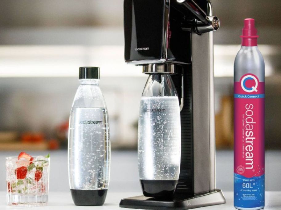 black soda maker machine with clear water bottles