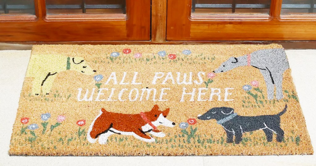 doormat with multiple dogs that says "all paws welcome here"