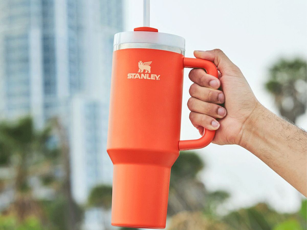 Stanley 40oz Tumbler in new tigerlily orange shade being held up in a hand