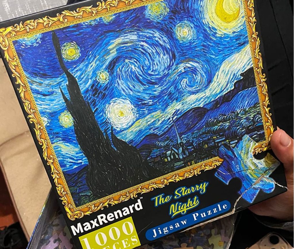 hand holding lid to box for Vincent Van Gogh Starry Night Puzzle