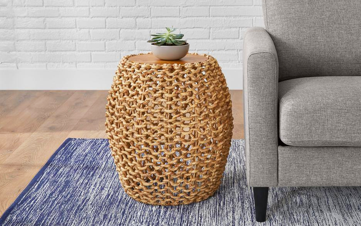 woven drum shape accent table next to grey chair