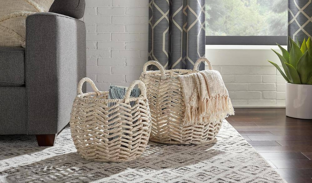 Two baskets sitting on an area rug next to a couch