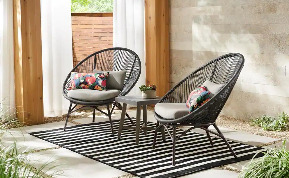 Two papasan style chairs on a rug on a patio