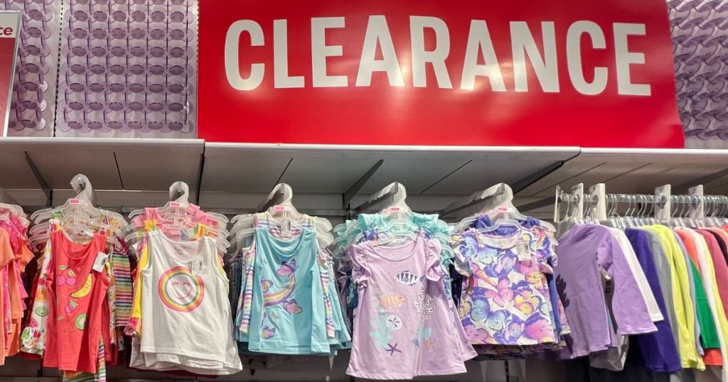 huge "CLEARANCE" sign in store with girls outfits hanging beneath sign