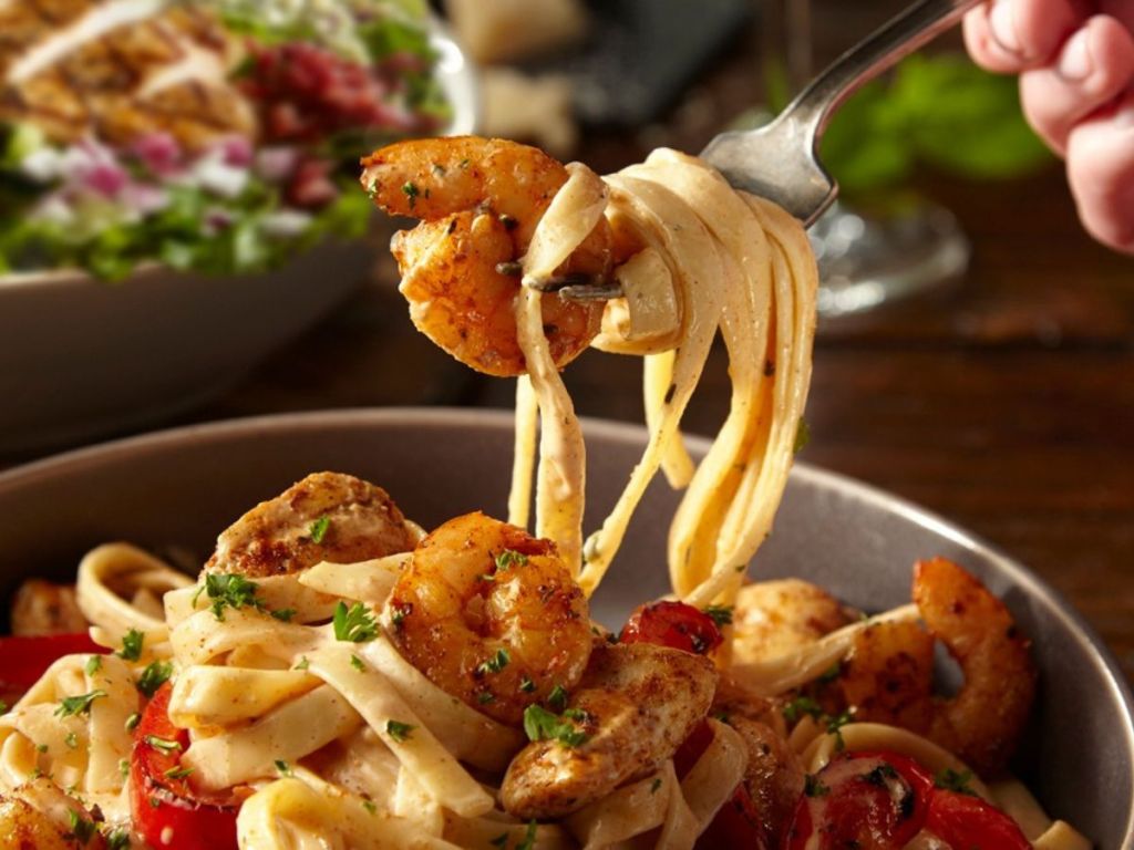 Fork taking a bite of TGI Friday's crispy shrimp pasta from a bowl