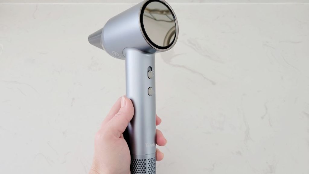 Hand holding a grey hair dryer