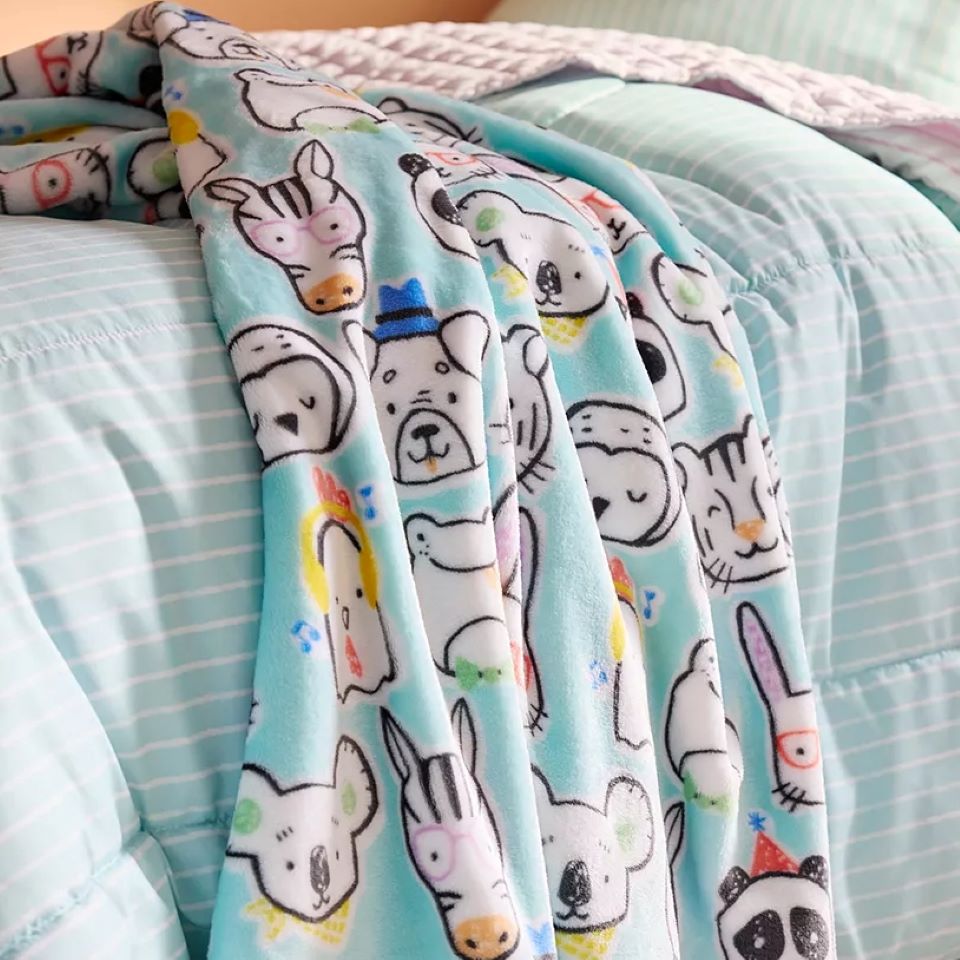 Throw blanket on a bed with a bunch of animals on it