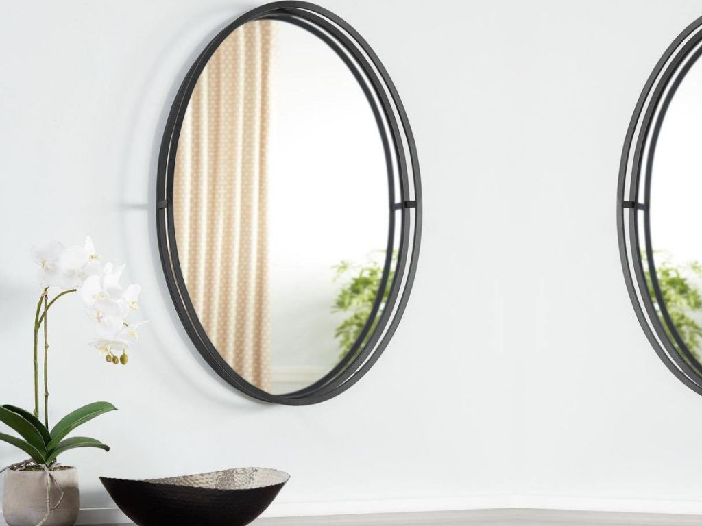 Wall with an oval accent mirror on it