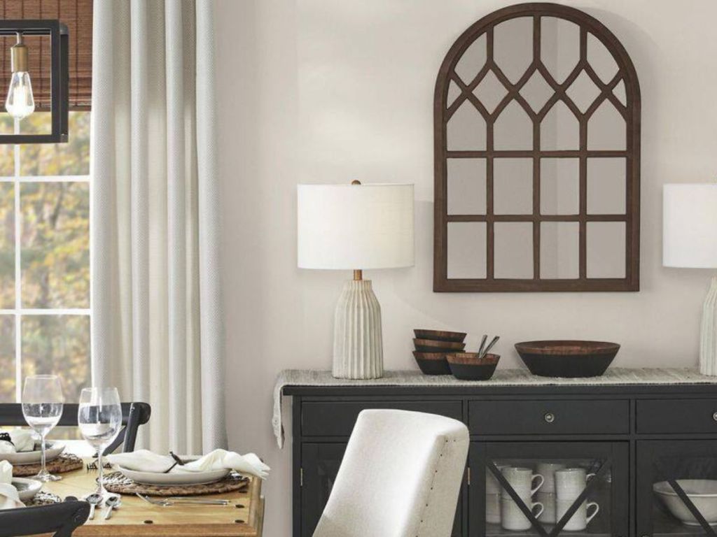 Windowpane accent mirror hanging in dining room above a hutch