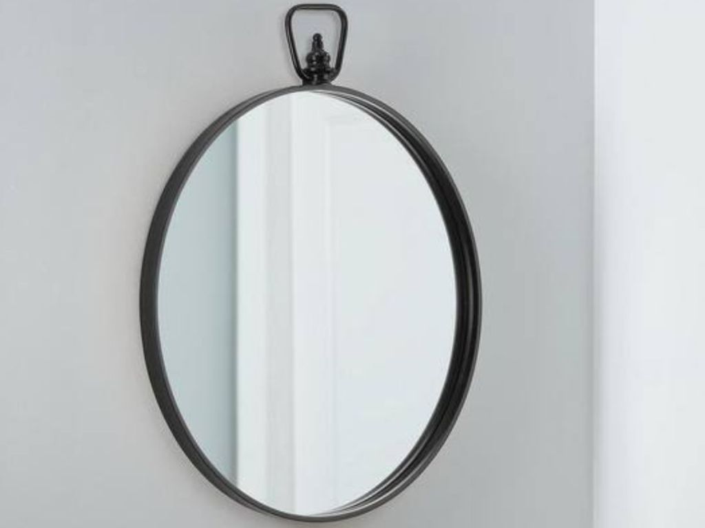 Round accent mirror hanging on wall