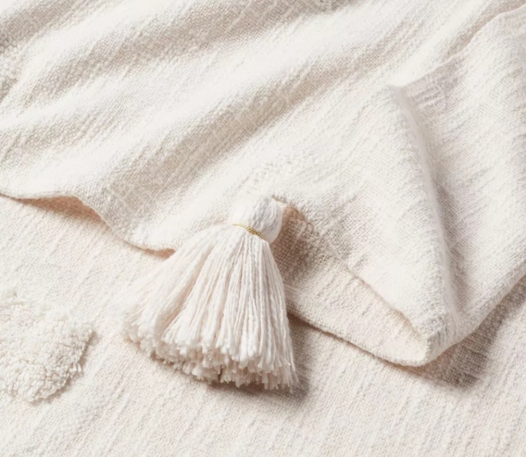 White blanket with a tassel on the end