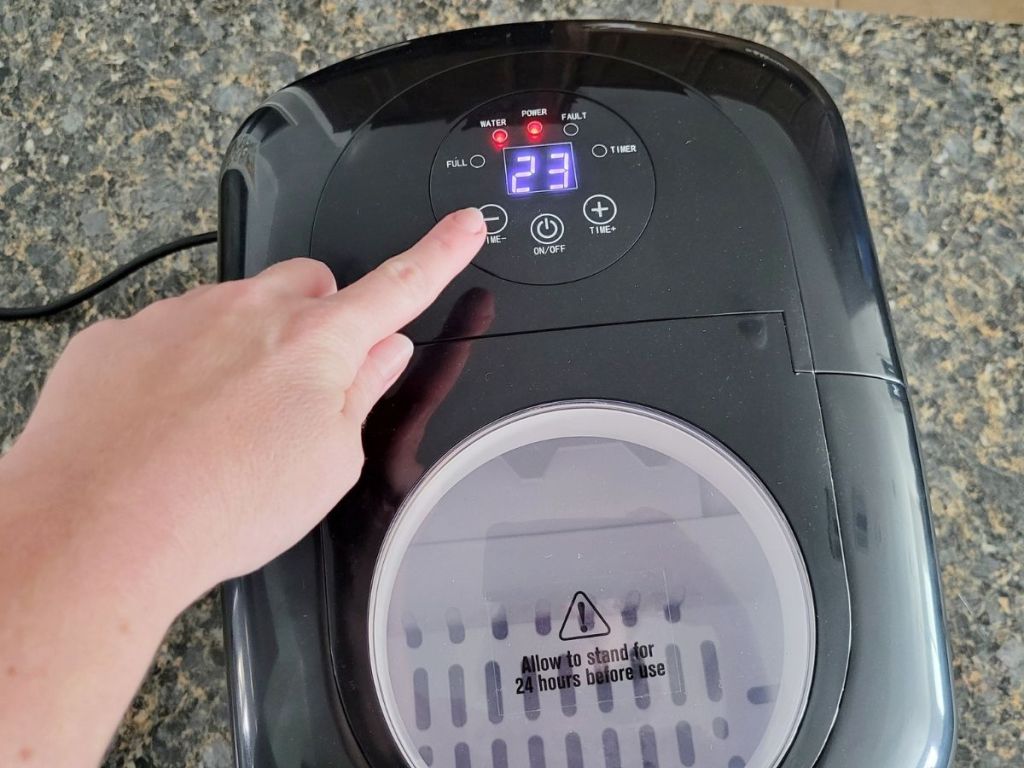 hand touching the buttons on a Trustech ice maker