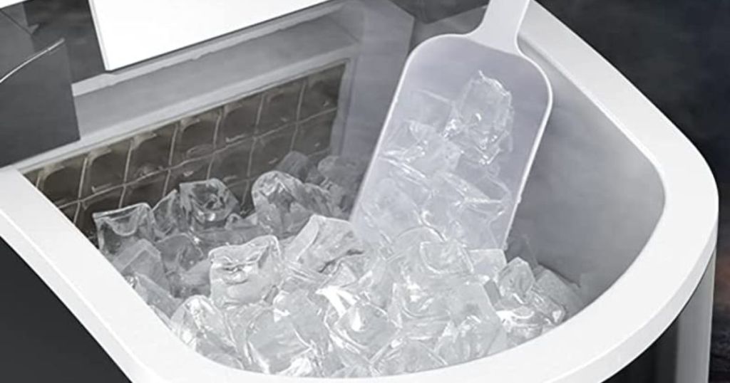 open Trustech ice maker with lots of ice cubes and a scoop inside