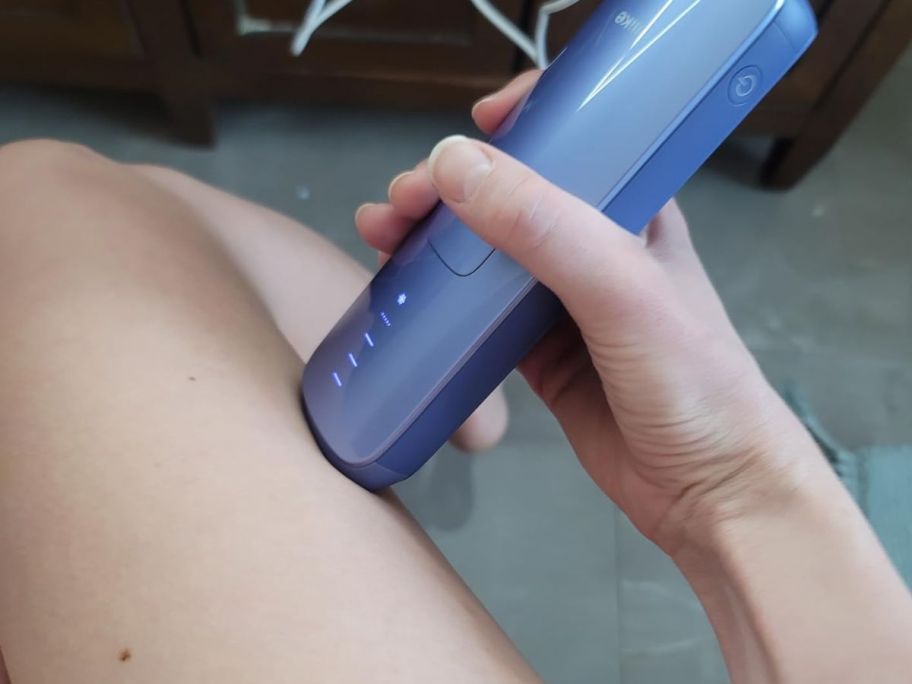 Woman using a Ulike IPL Laser Hair Removal handset on her leg