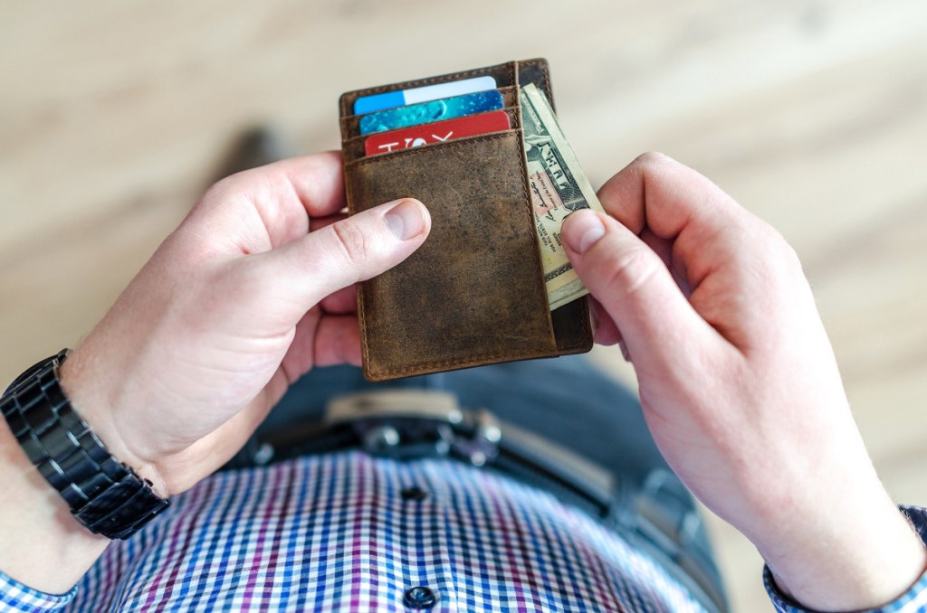 Man pulling money out of his wallet to buy Costco eye glasses