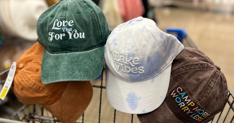 A group of 4 baseball caps in a shopping cart