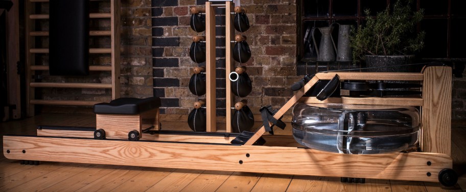 light wood rowing machine on wood floor with water 